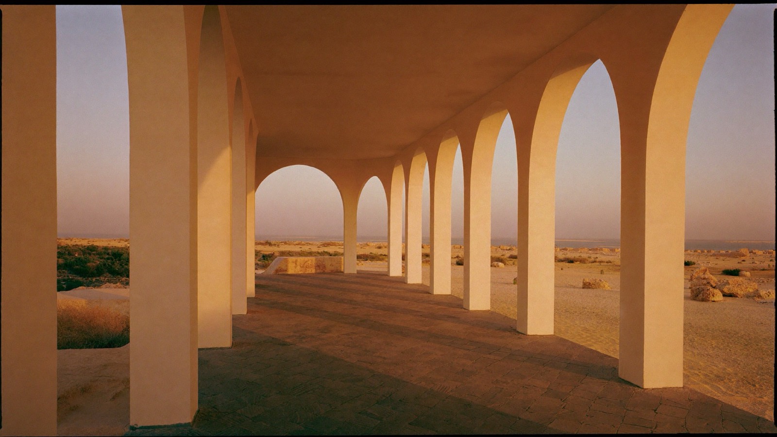 Afternoon light through a colonnade of stone arches